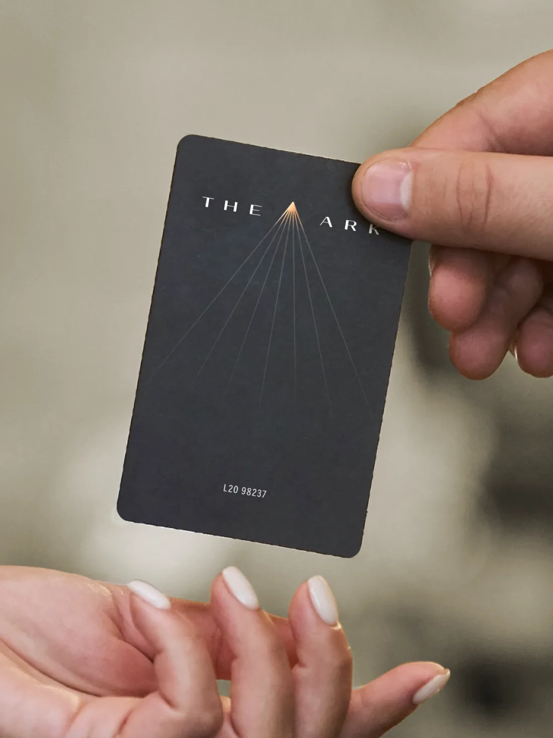 Hands exchanging a black The Ark access card