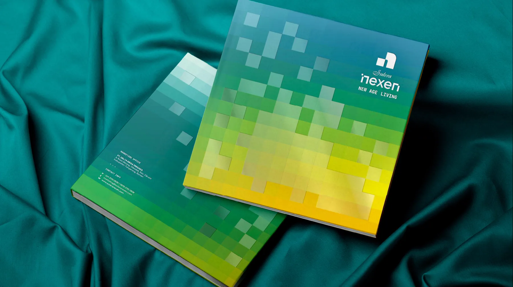 Two Nexen brochures with pixel-gradient covers on teal fabric