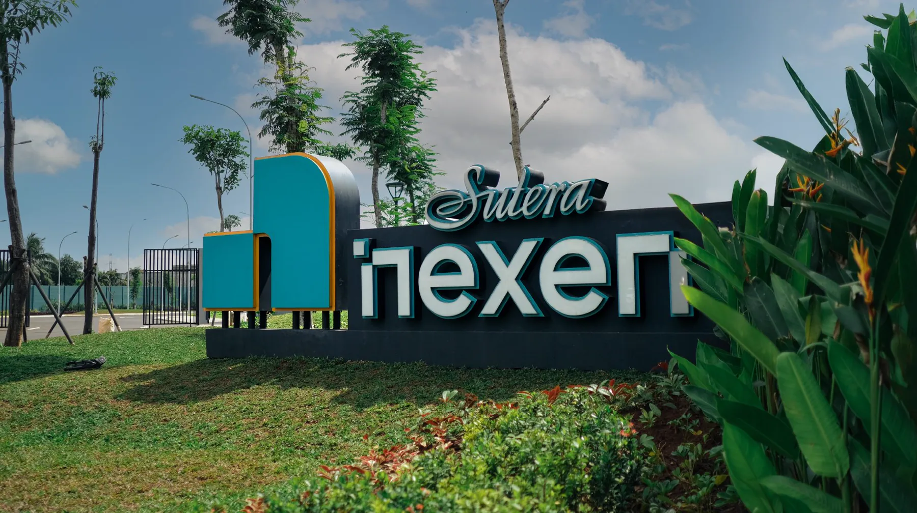 Sutera Nexen township sign on a lawn, a teal N-shaped marker beside the letters