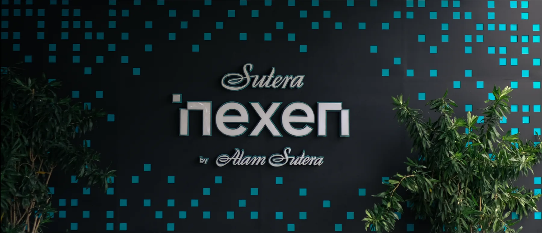Nexen logo with “by Alam Sutera” on a black wall scattered with teal pixels