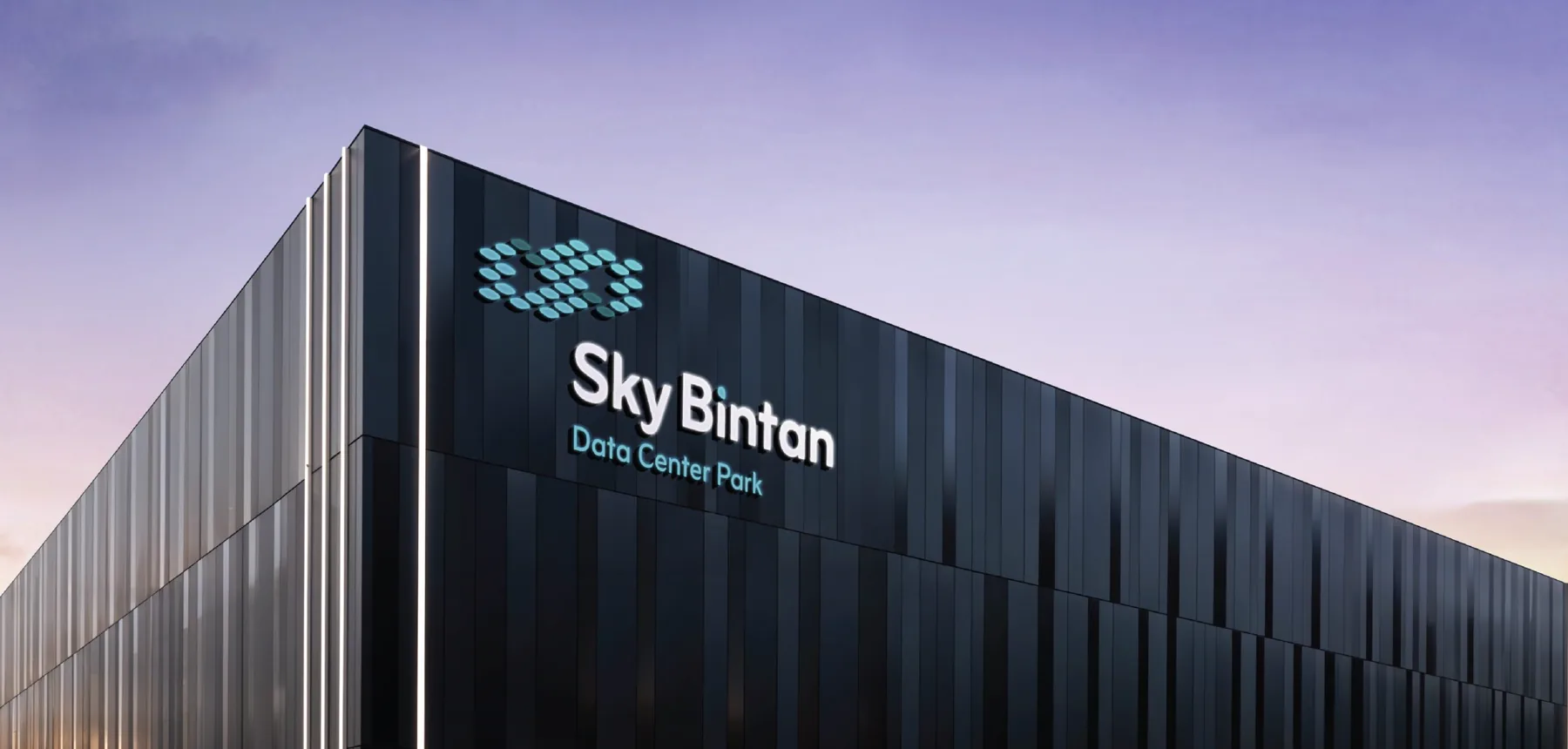 Corner of a dark data center building at dusk with the Sky Bintan Data Center Park sign